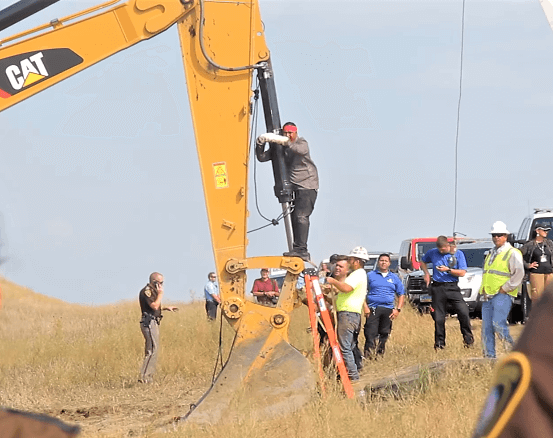 Water Protector "Happi" American Horse locks himself to construction equipment.