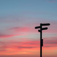 Silhouette of a signpost in front of an evening sky
